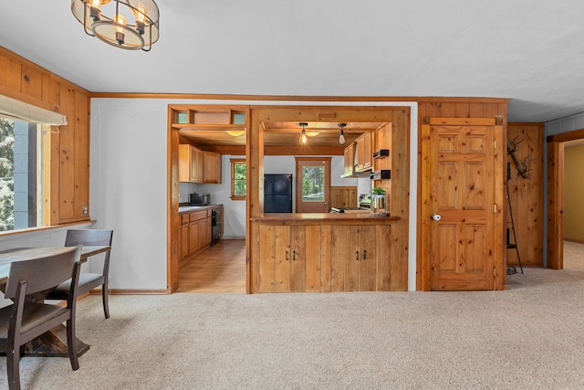 2184 Clugston Onion Creek Rd, Colville, WA 99114 - kitchen with freestanding refrigerator, light carpet, wooden walls, range, and a chandelier