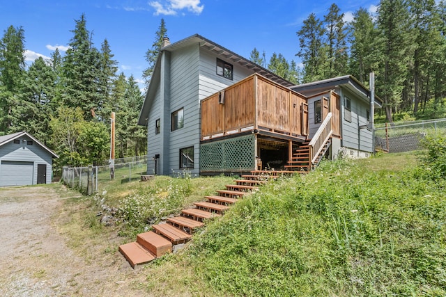 2184 Clugston Onion Creek Rd, Colville, WA 99114 - back of property featuring stairway, a deck, a detached garage, a chimney, and an outdoor structure