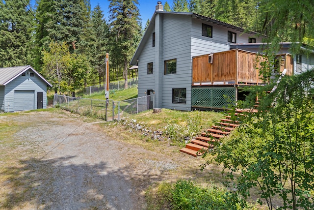2184 Clugston Onion Creek Rd, Colville, WA 99114 - view of side of property featuring stairway, a chimney, a detached garage, dirt driveway, and a deck