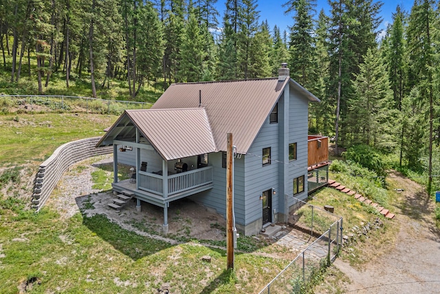 2184 Clugston Onion Creek Rd, Colville, WA 99114 - view of side of property with a chimney, a view of trees, a metal roof, and a wooden deck