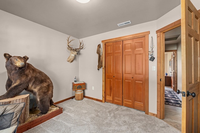 carpeted bedroom featuring baseboards, visible vents, and a closet