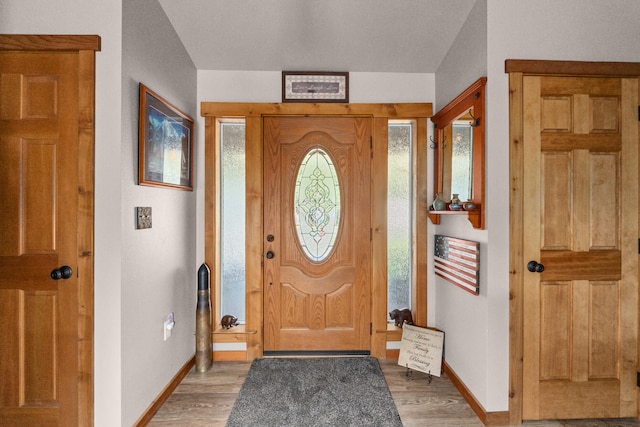 foyer entrance with baseboards and light wood-style floors