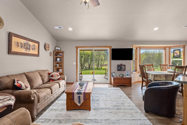 living area with recessed lighting, vaulted ceiling, wood finished floors, and visible vents