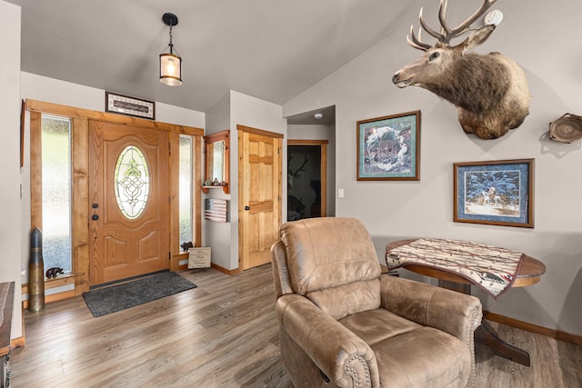 entrance foyer featuring baseboards, wood finished floors, and vaulted ceiling