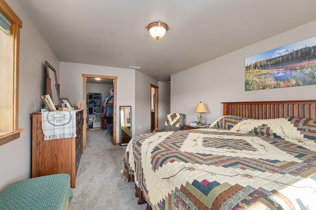 carpeted bedroom with a closet and a spacious closet