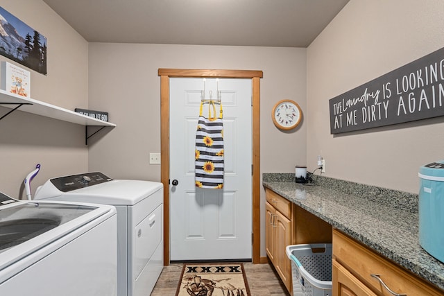 laundry area with light wood finished floors and independent washer and dryer