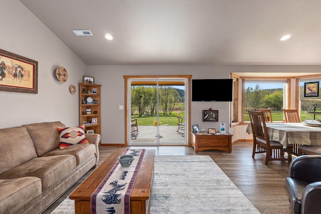 living area featuring recessed lighting, visible vents, wood finished floors, and vaulted ceiling
