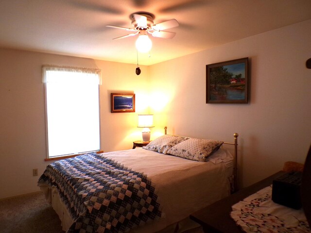 bedroom with multiple windows, carpet, and a ceiling fan