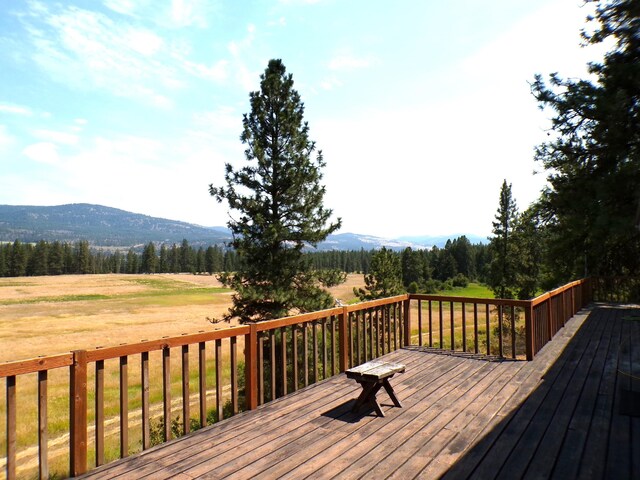 wooden deck featuring a mountain view and a view of trees