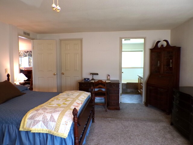 bedroom with visible vents, connected bathroom, and carpet flooring