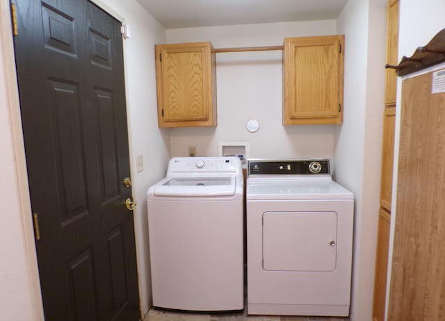 washroom featuring cabinet space and washer and clothes dryer