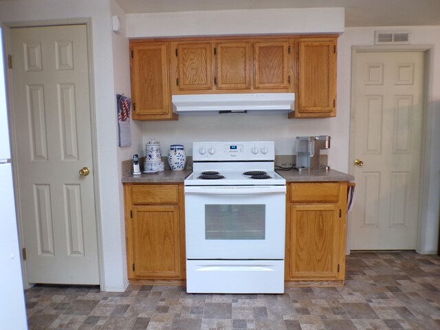 kitchen featuring visible vents, electric range, under cabinet range hood, stone finish flooring, and dark countertops