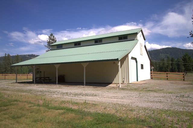 1425 Chapin Rd N, Evans, WA 99126 - rear view of property featuring a detached garage, a metal roof, a mountain view, an outdoor structure, and driveway