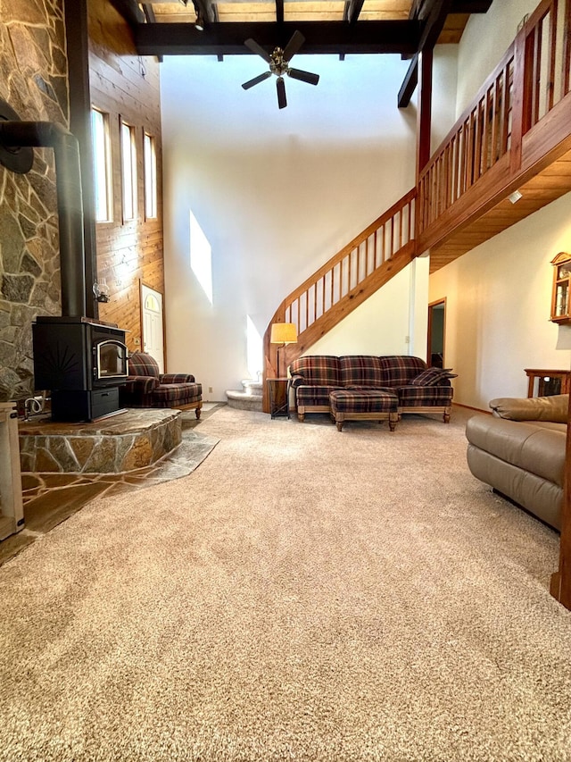 1425 Chapin Rd N, Evans, WA 99126 - living room featuring a towering ceiling, carpet, a ceiling fan, a wood stove, and stairway