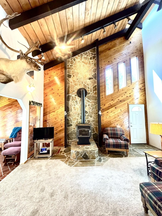 1425 Chapin Rd N, Evans, WA 99126 - carpeted living room featuring wood walls, a wood ceiling with exposed beams, a wood stove, and high vaulted ceiling