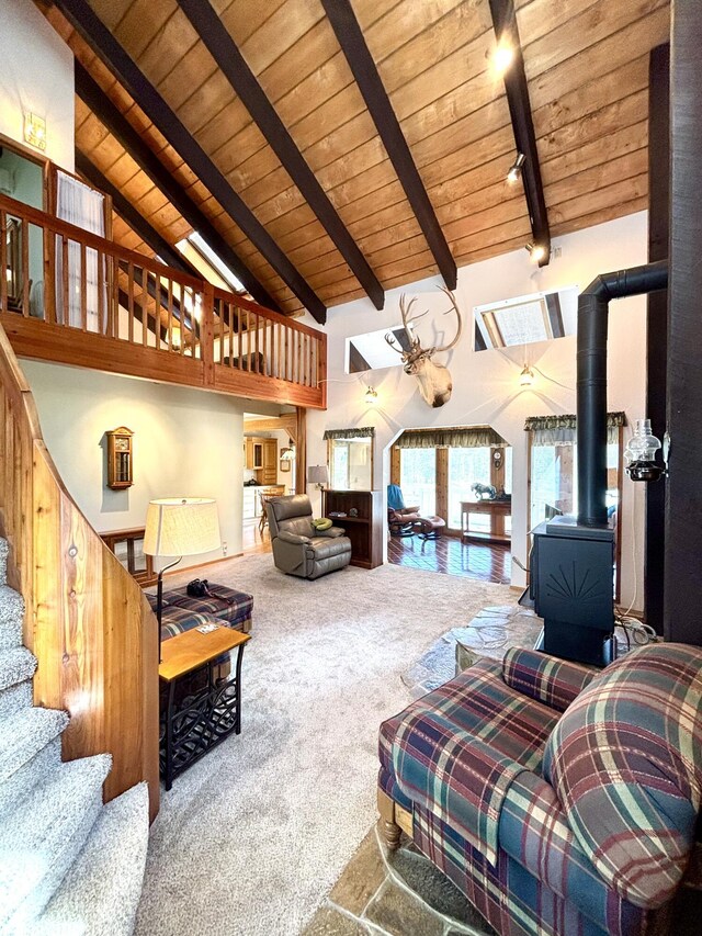 1425 Chapin Rd N, Evans, WA 99126 - living area featuring a wood ceiling with exposed beams, carpet floors, a wood stove, high vaulted ceiling, and stairs