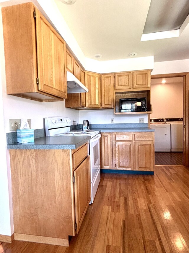 1425 Chapin Rd N, Evans, WA 99126 - kitchen with white electric range, under cabinet range hood, black microwave, washing machine and dryer, and dark wood-type flooring