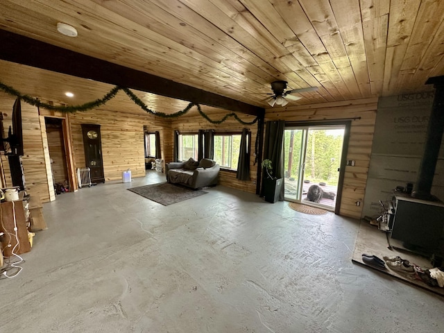6171 Coyote Canyon Rd Unit L, Fruitland, WA 99129 - unfurnished living room with unfinished concrete floors, a wood stove, ceiling fan, wood ceiling, and wood walls