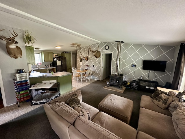 living room with a wood stove and beam ceiling