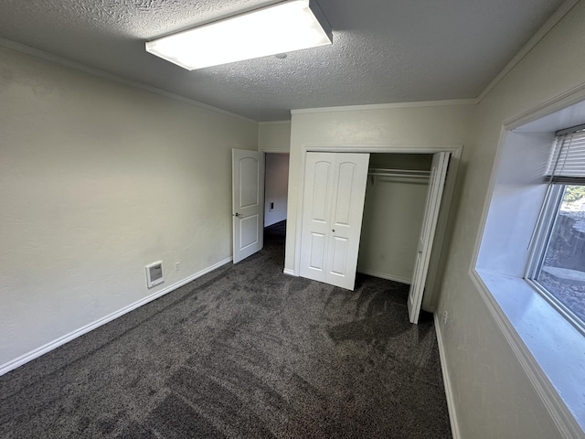 360 E 7th Ave, Colville, WA 99114 - unfurnished bedroom with dark colored carpet, a textured ceiling, a closet, and ornamental molding