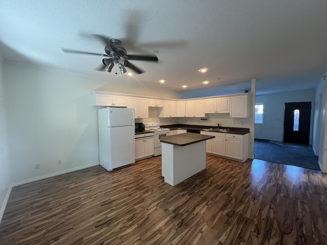 360 E 7th Ave, Colville, WA 99114 - kitchen featuring white appliances, dark countertops, dark wood-type flooring, white cabinetry, and a center island