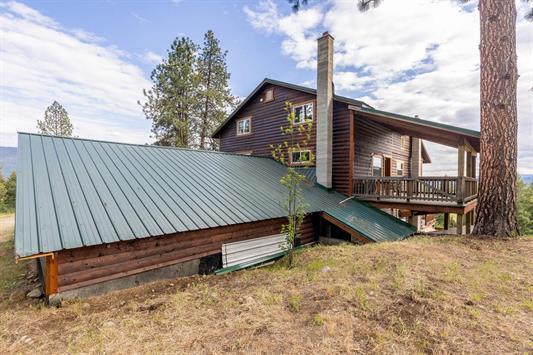 rear view of house featuring metal roof and a wooden deck