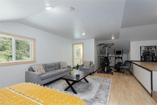 living area with light wood-style floors, recessed lighting, and vaulted ceiling