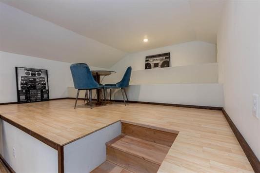 additional living space with lofted ceiling, wood finished floors, and baseboards