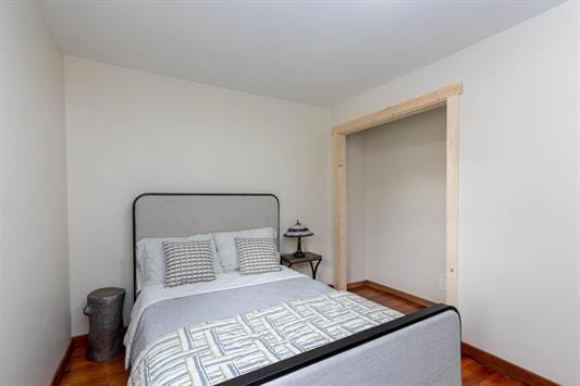 bedroom with baseboards and wood finished floors