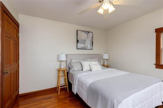 bedroom with a ceiling fan, baseboards, and wood finished floors