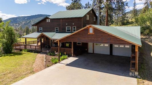 view of front of property with a garage, covered porch, driveway, and a mountain view