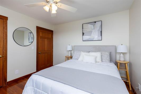 bedroom featuring ceiling fan, baseboards, and dark wood-style flooring