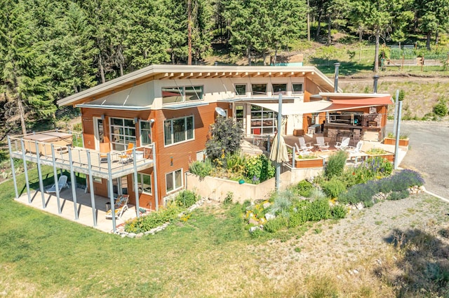 exterior space with a patio area, a lawn, and a wooden deck