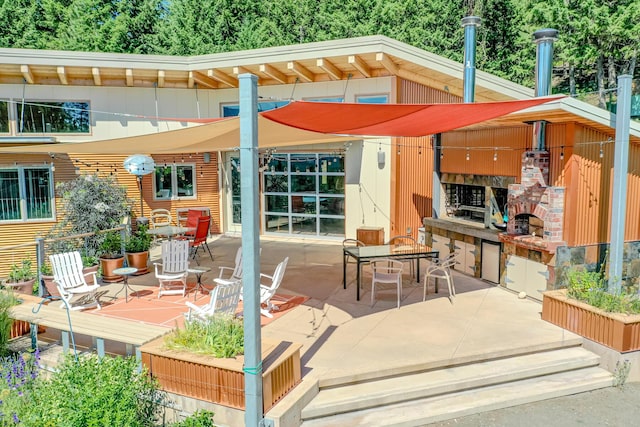 view of patio / terrace featuring an outdoor brick fireplace and outdoor dining space