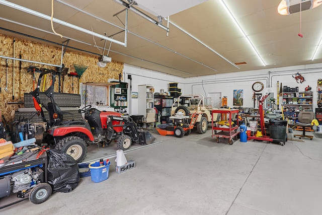 garage featuring a garage door opener and a workshop area