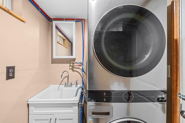 laundry room with stacked washing maching and dryer and sink