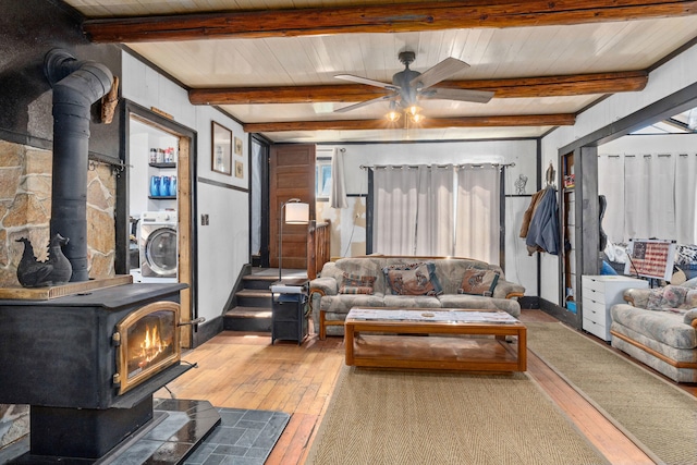 3063 Hungry Hill Rd, Kettle Falls, WA 99141 - living room with a wood stove, light wood-style floors, a ceiling fan, baseboards, and beam ceiling