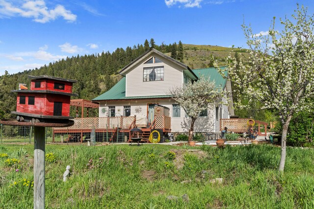 3063 Hungry Hill Rd, Kettle Falls, WA 99141 - back of property featuring a deck with mountain view and a wooded view
