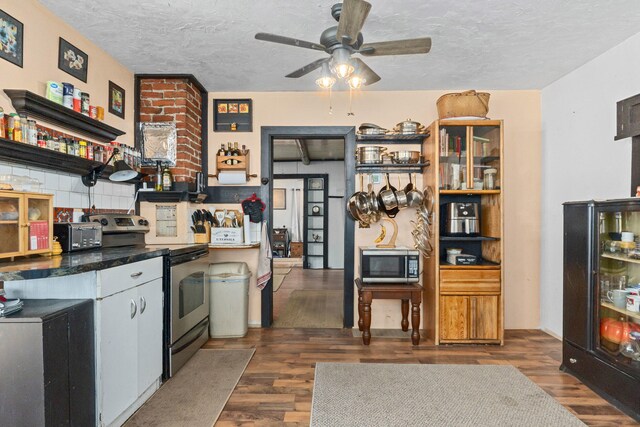 3063 Hungry Hill Rd, Kettle Falls, WA 99141 - kitchen with appliances with stainless steel finishes, dark wood-style flooring, ceiling fan, open shelves, and a textured ceiling