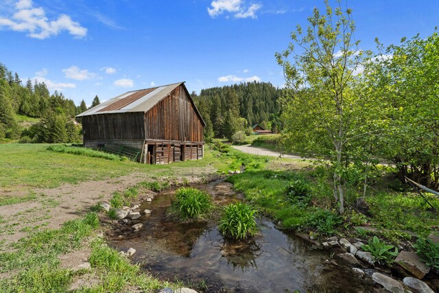 3063 Hungry Hill Rd, Kettle Falls, WA 99141 - view of side of home with a barn, an outdoor structure, and a forest view