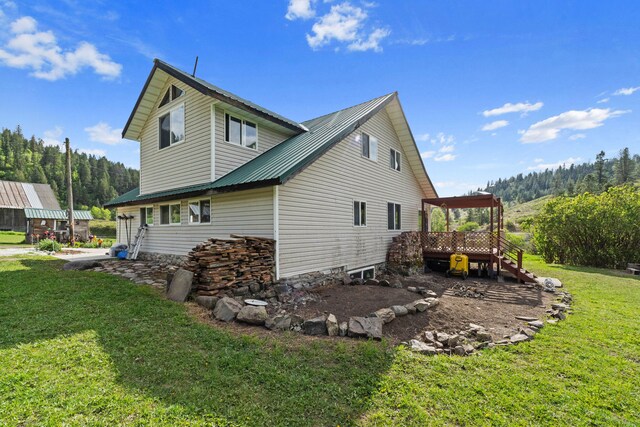 3063 Hungry Hill Rd, Kettle Falls, WA 99141 - view of side of home with a yard, a deck, stairs, and metal roof