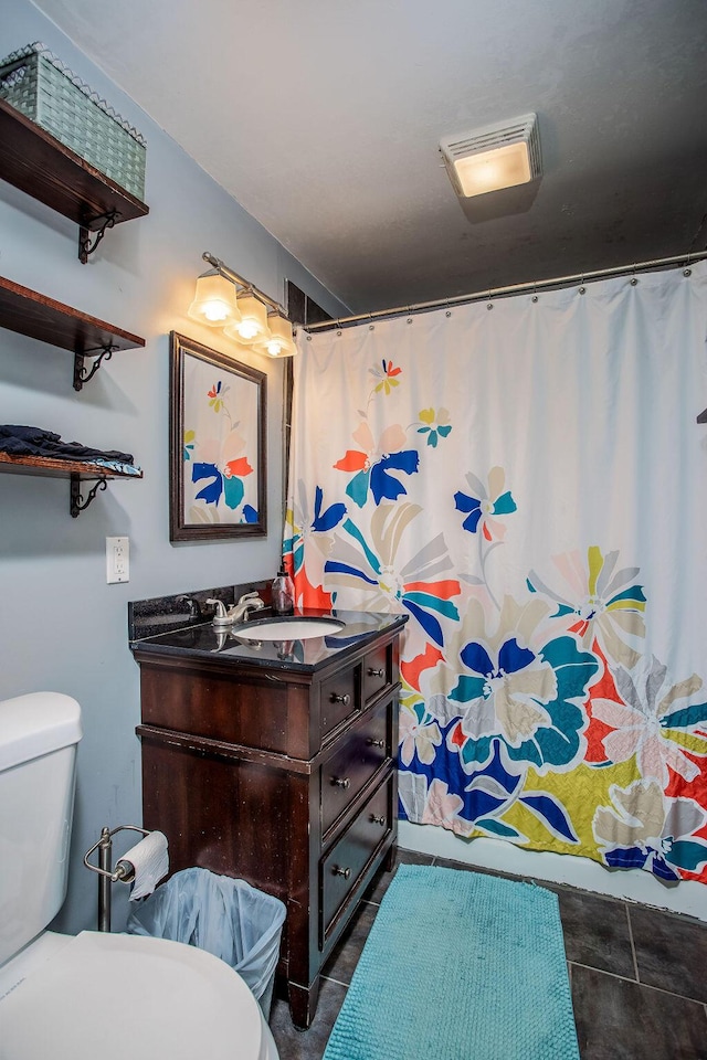 bathroom featuring toilet, vanity, and a shower with shower curtain