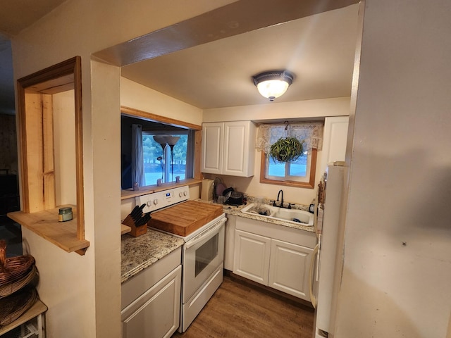 kitchen with white appliances, white cabinetry, sink, dark wood-type flooring, and light stone counters