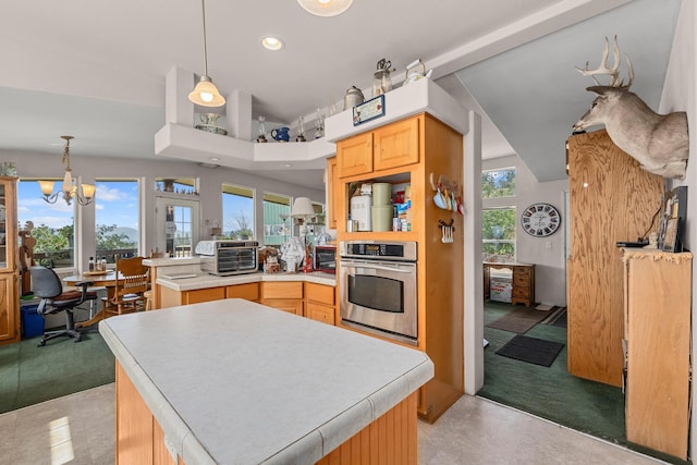 kitchen featuring stainless steel oven, a peninsula, a toaster, and light colored carpet
