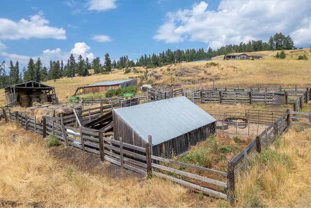 view of yard featuring a rural view, an outbuilding, and an exterior structure