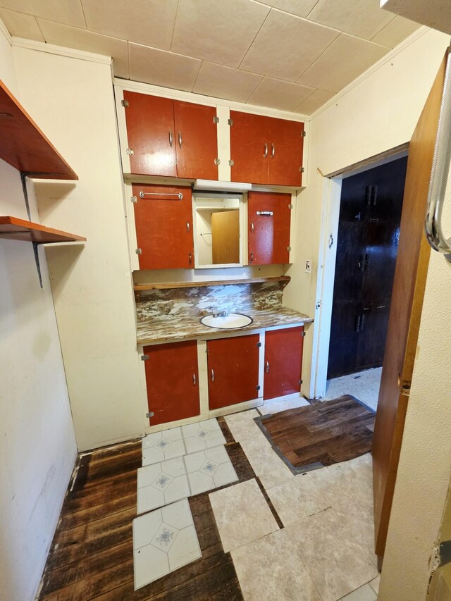 707 N 4th St W, Chewelah, WA 99109 - kitchen featuring red cabinets, tile patterned flooring, open shelves, and inlaid floor details