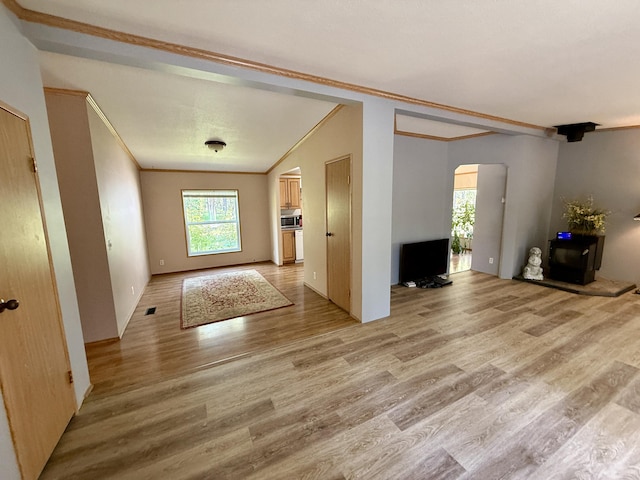 1874 Brooks Rd, Evans, WA 99126 - unfurnished living room with arched walkways, crown molding, and light wood-style flooring