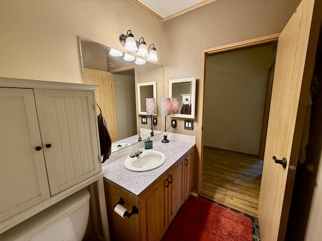1874 Brooks Rd, Evans, WA 99126 - half bathroom featuring vanity, wood finished floors, and crown molding
