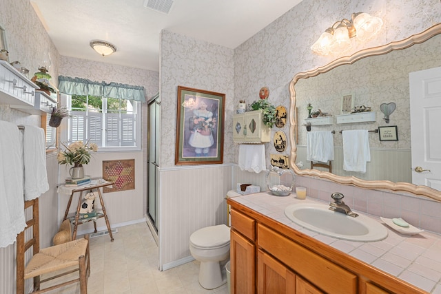 76 Kifer Rd, Kettle Falls, WA 99141 - bathroom with wainscoting, a shower stall, vanity, wallpapered walls, and tile patterned floors