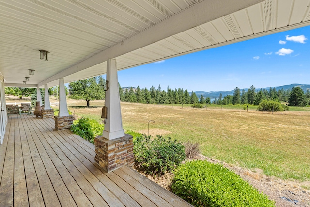 76 Kifer Rd, Kettle Falls, WA 99141 - wooden porch with a mountain view and a lawn